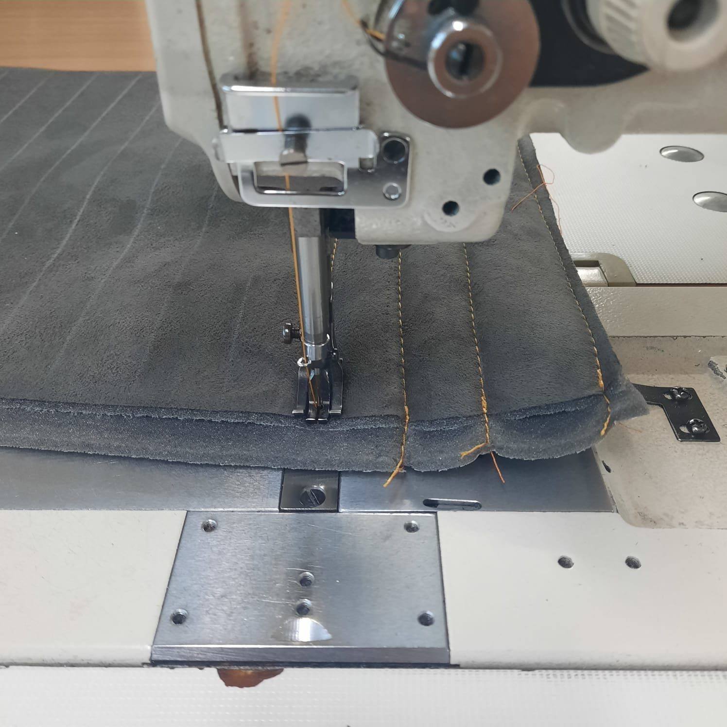 Nähmaschine bei der Anfertigung individueller Quernähte für maßgeschneiderte Autositzbezüge