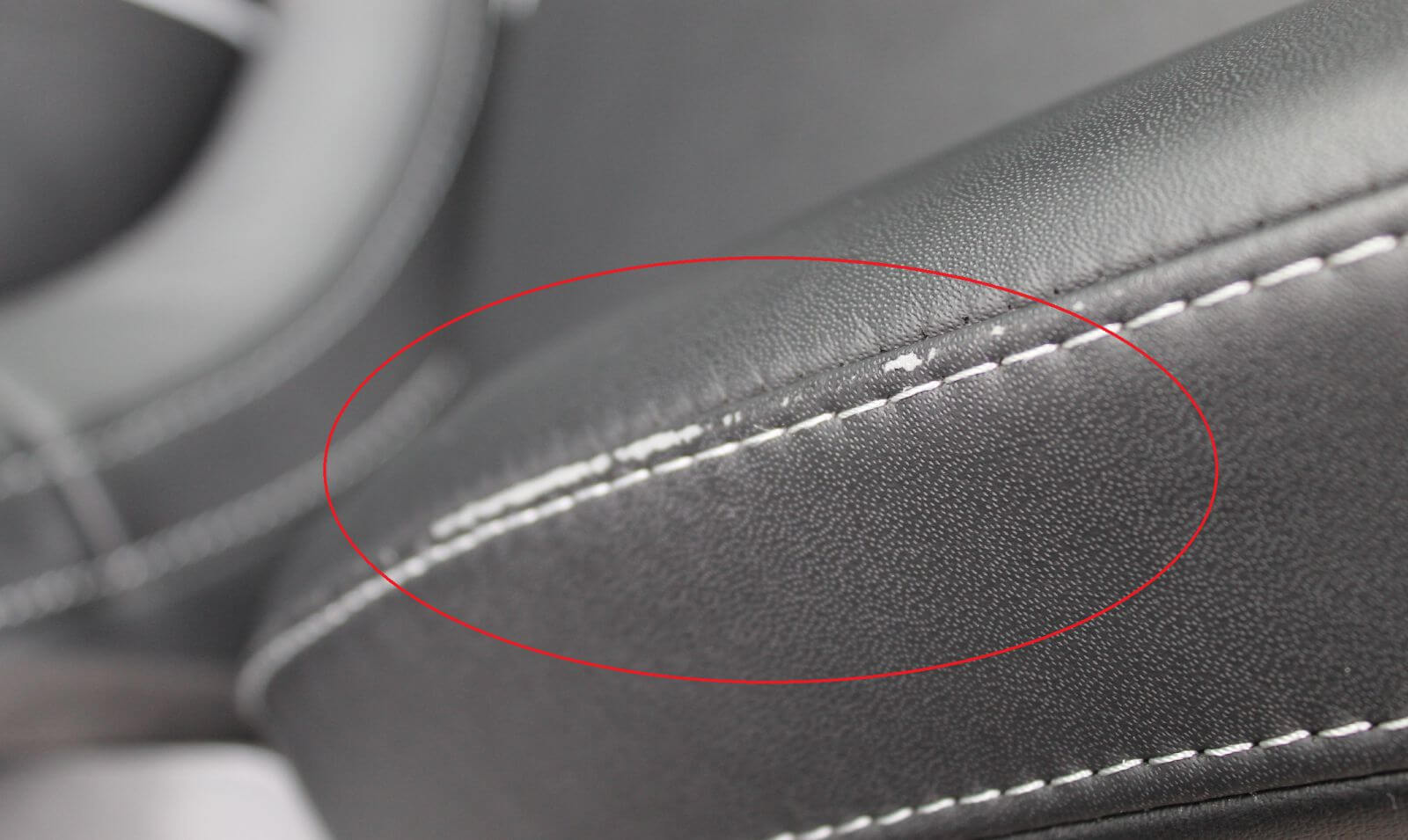 Deutliche Abnutzung an der Fahrersitzlehne eines Originalautositzes nach drei Jahren durch häufiges Ein- und Aussteigen.